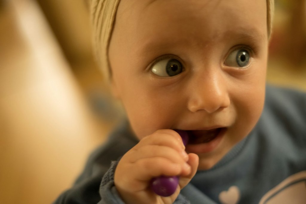 Baby using a safe teething toy, illustrating natural baby teething remedies