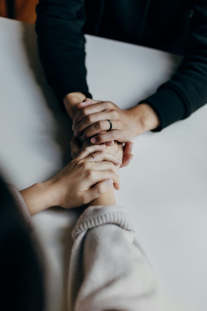 Coping With Grief: What Actually Helps You Through It 2 Two hands clasped together in comfort, representing support while coping with grief