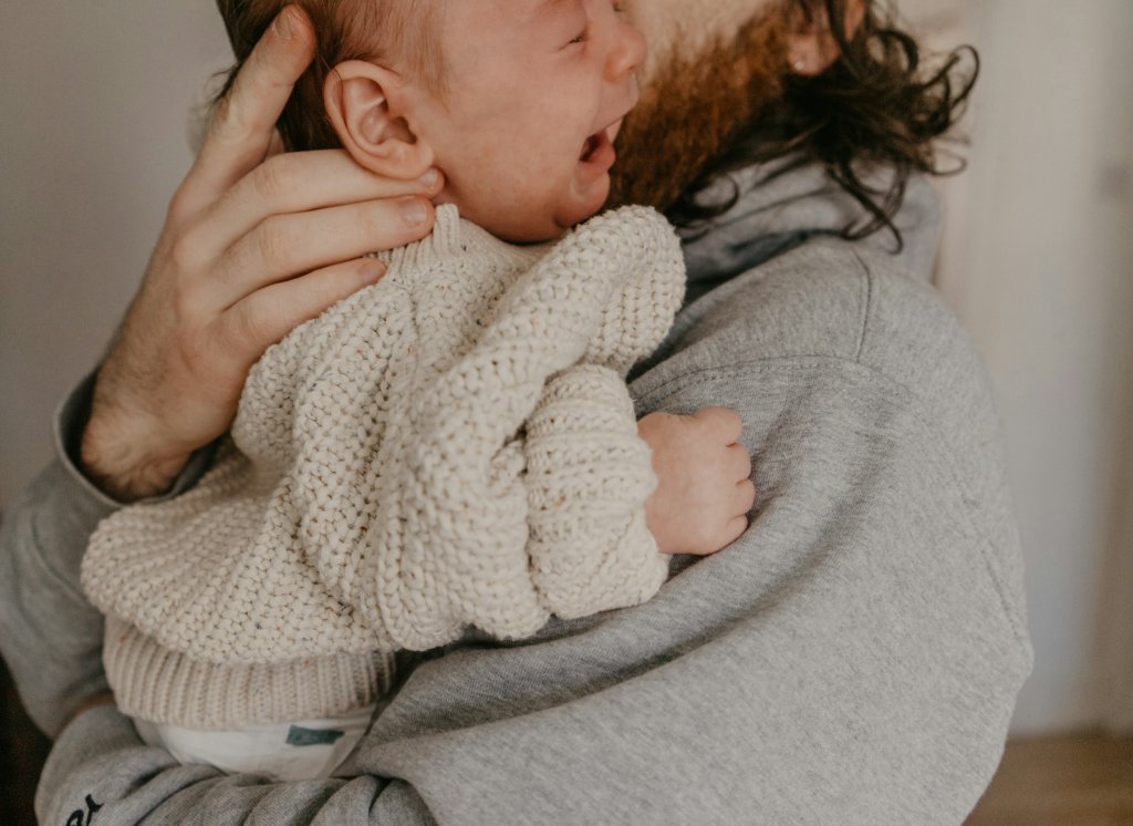 Soothing Infant Colic: Natural Ways That Actually Help 2 Parent gently holding and soothing a baby experiencing infant colic