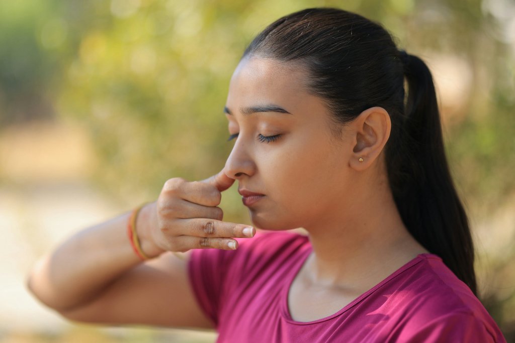 Woman practicing calming breathing outdoors to manage anxiety naturally