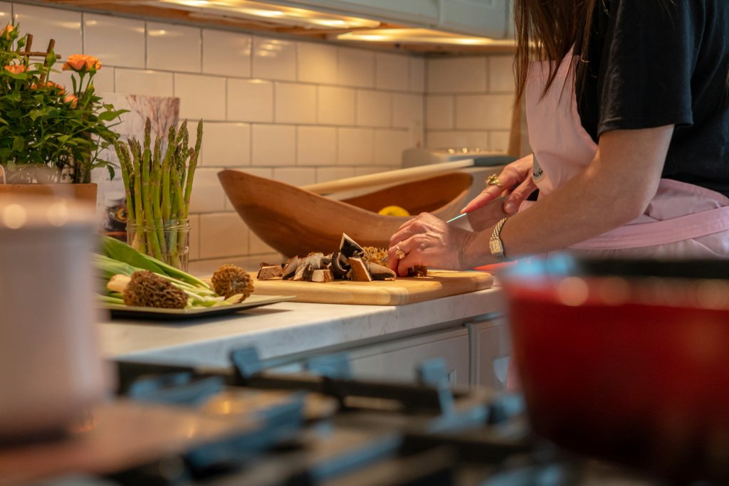 Managing PCOS Naturally: What the Research Actually Shows 2 Woman preparing a vegetable-rich meal, part of managing PCOS naturally