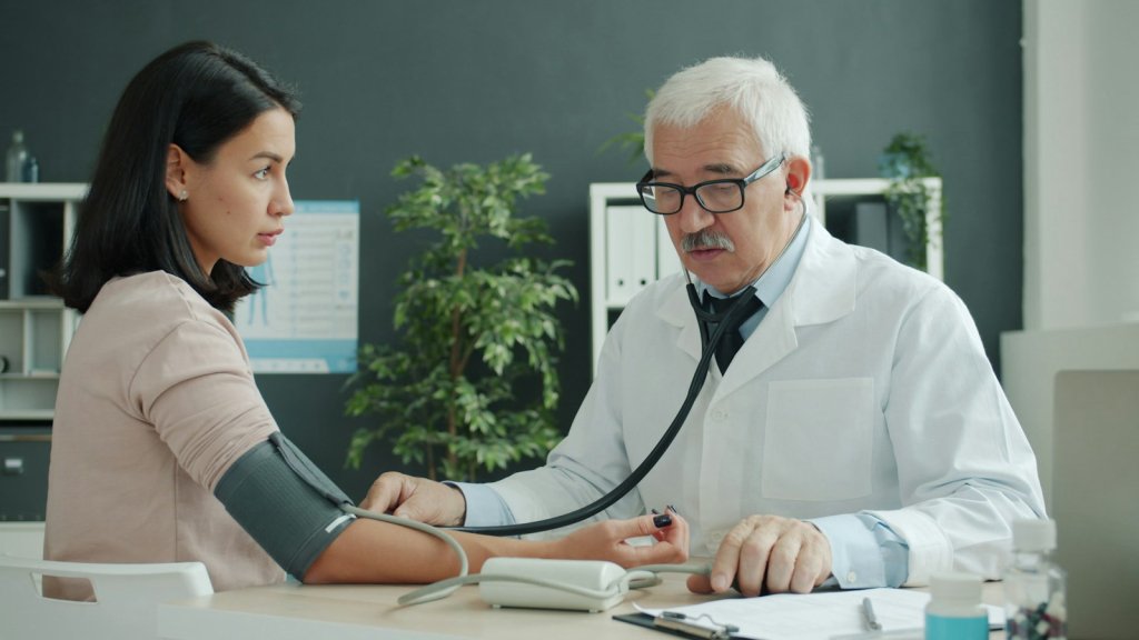 Men's Health Screenings: What to Get Checked by Age 2 Doctor checking a patient's blood pressure during routine men's health screenings