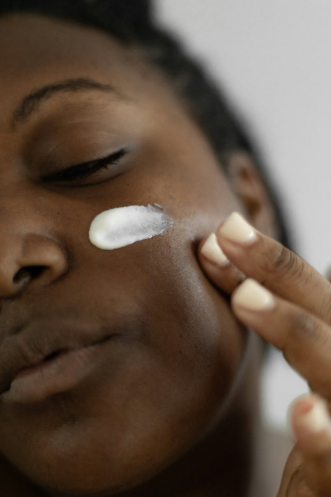 Seasonal Skin Care: What to Change as Weather Cools 2 Woman applying a rich moisturizer to her face as part of a seasonal skin care routine