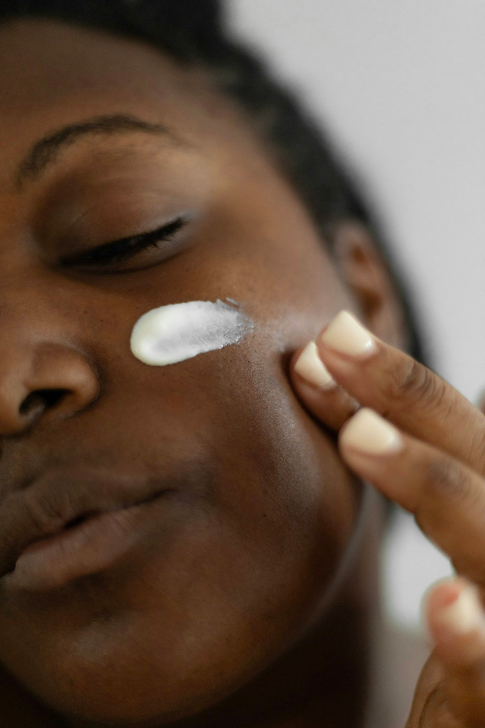 Home 41 Woman applying a rich moisturizer to her face as part of a seasonal skin care routine