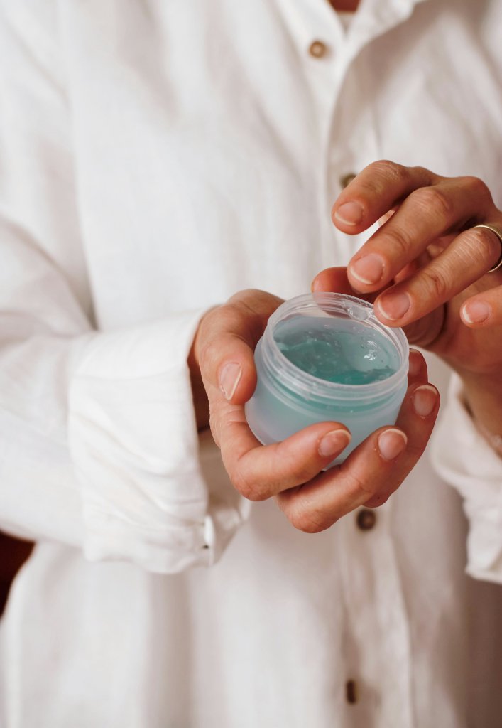 Hand holding a moisturizer used as part of a gentle skin barrier repair routine