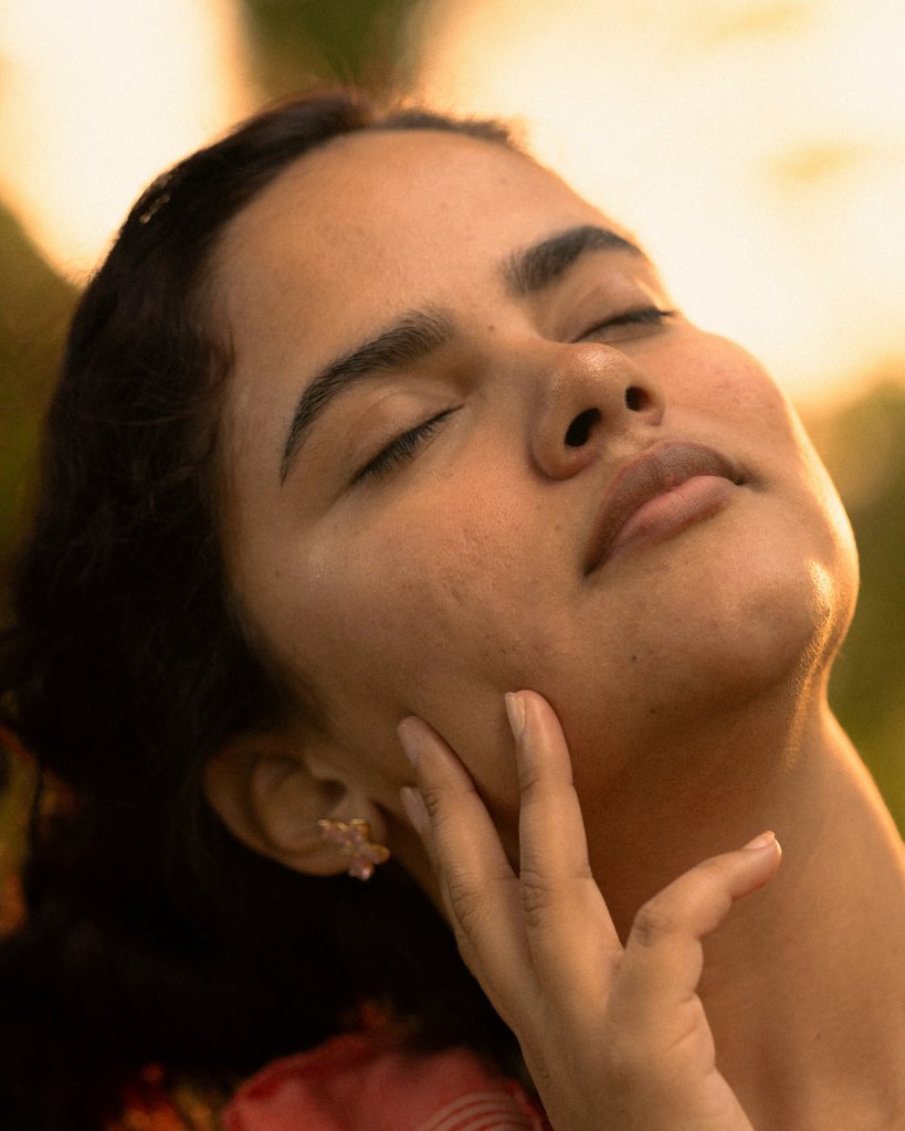 The Stress and Skin Connection: What Actually Helps 2 Woman gently touching her face, illustrating the stress and skin connection