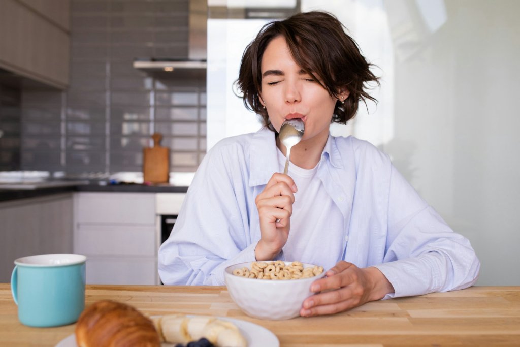 Emotional Eating: How to Spot It and Respond Kindly 2 Woman eating cereal from a bowl, a common emotional eating moment