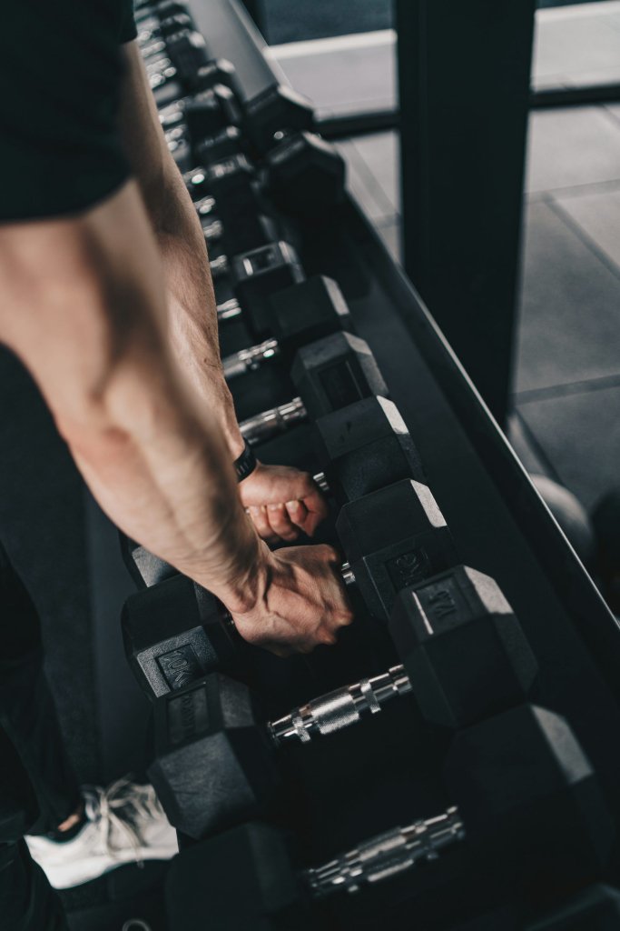 Muscle Loss After 40: How Men Can Stay Strong Longer 2 Man doing dumbbell strength training in a gym to help prevent muscle loss after 40