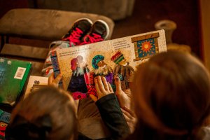 Home 44 Two children reading books together on a sofa, a screen-free alternative for healthy screen time for kids