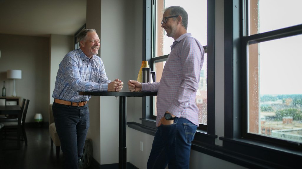 Sitting Too Much? Simple Ways to Move More at Work 2 Man standing at an office desk, a simple way to reduce sitting too much during the workday