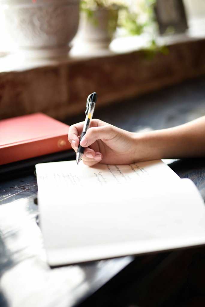 Person writing in a notebook to stop overthinking and sort racing thoughts